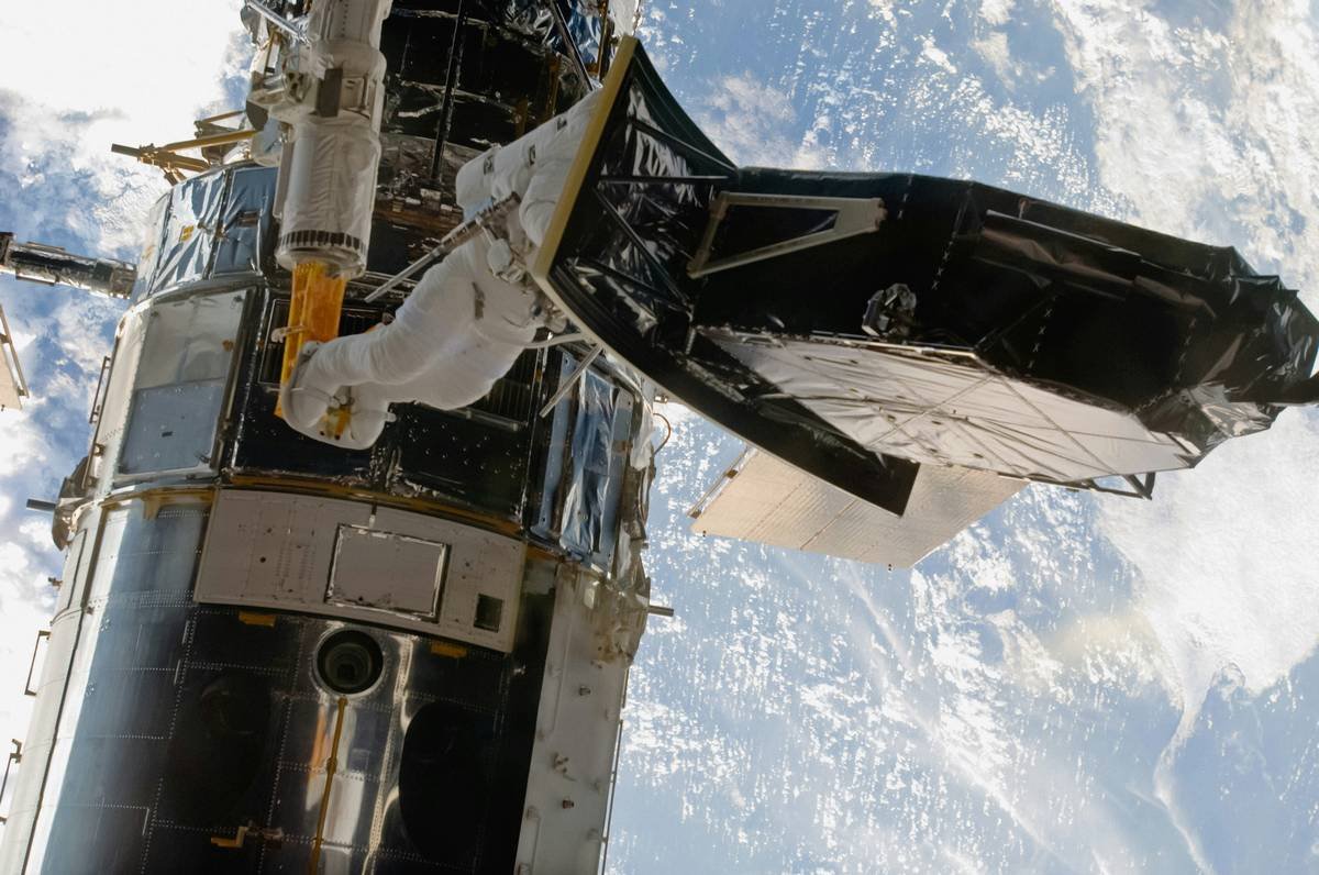 Installing Wide Field Camera 3 (2009) Caption Astronaut Andrew Feustel, perched on the end of the robotic arm, helps to install the Wide Field Camera 3 (WFC3) during a May 14, 2009, spacewalk to perform work on the Hubble Space Telescope. Wide Field Camera 3 is one of two new instruments installed during Servicing Mission 4, the fifth astronaut visit to Hubble. Credits NASA